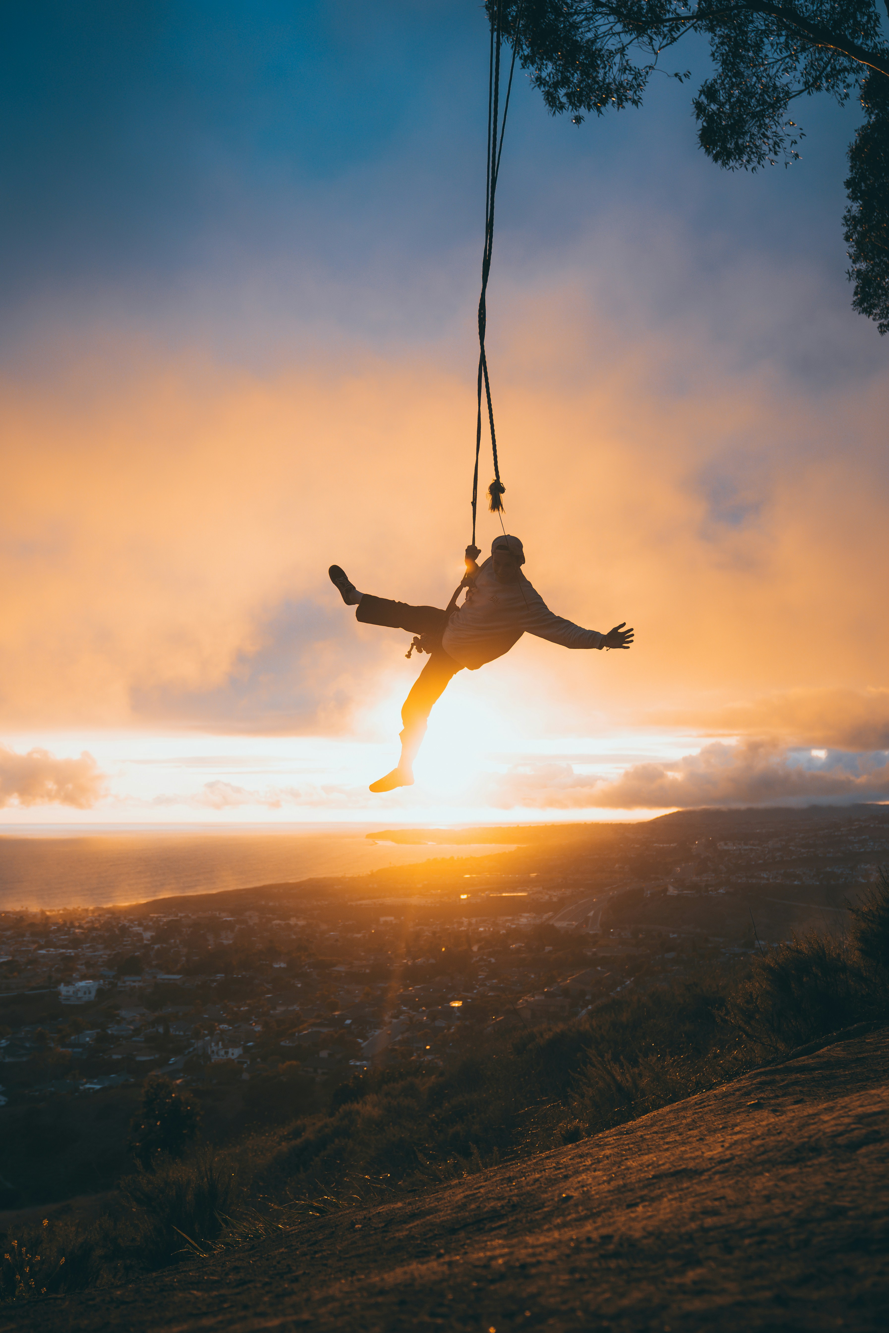 man in white shirt and black shorts jumping on mid air during sunset