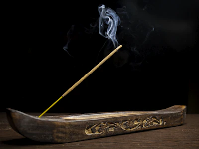 An elegant marble incense holder with subtle gold accents, surrounded by soft candlelight.