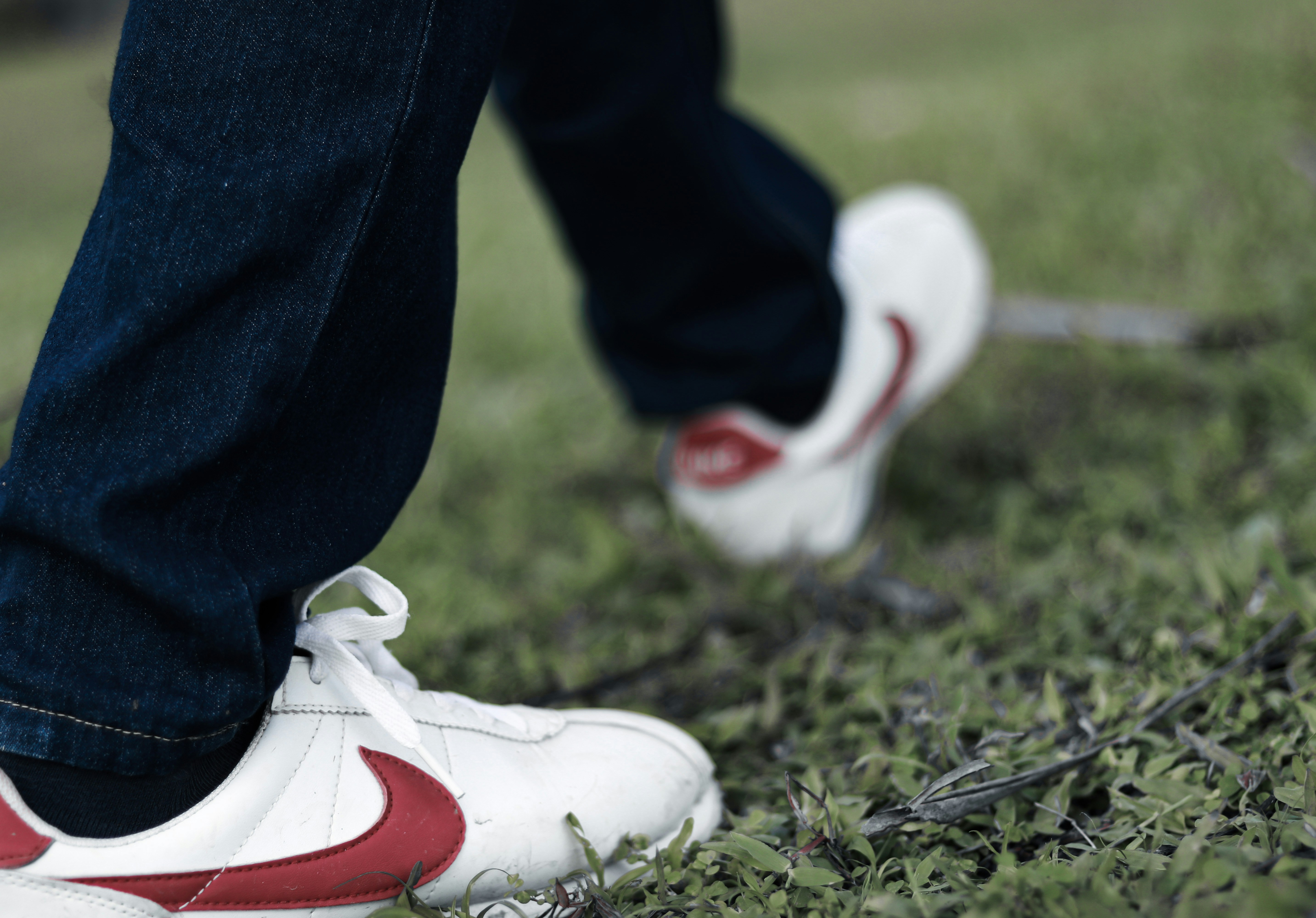 person in blue denim jeans and white nike sneakers