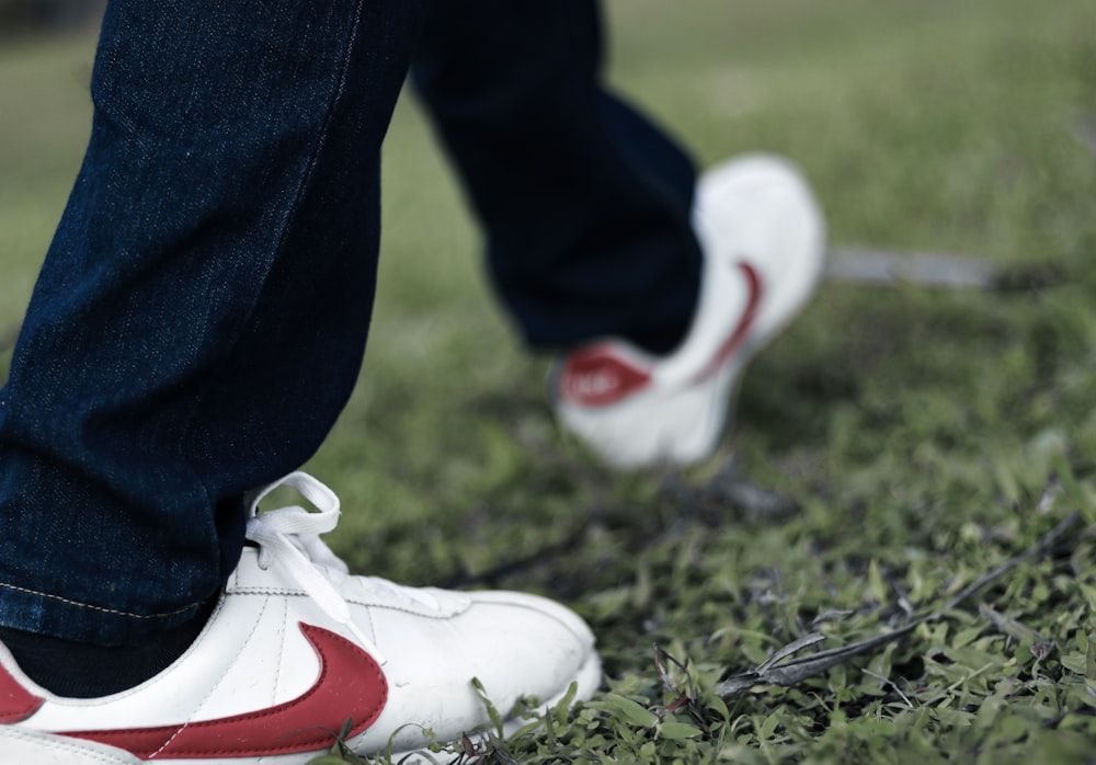 person in blue denim jeans and white nike sneakers