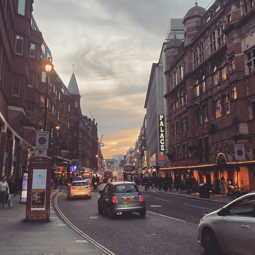 a busy city street at dusk with cars and people