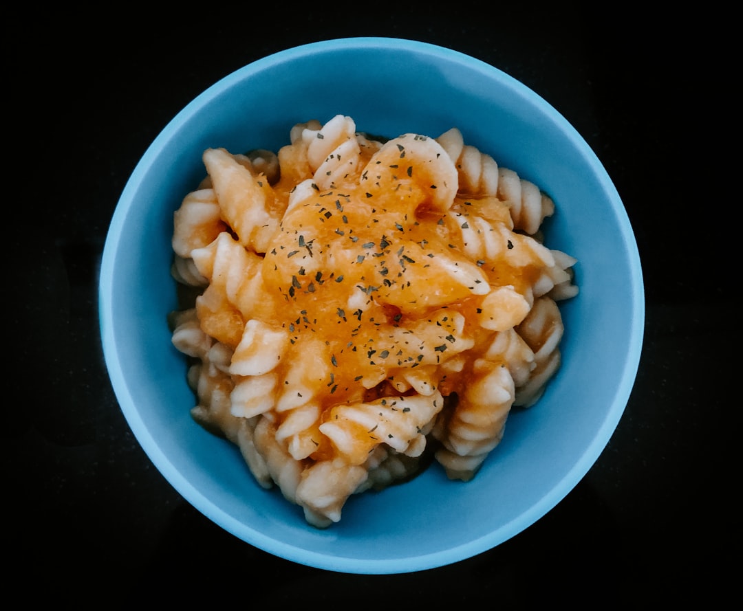 white and blue ceramic bowl with pasta