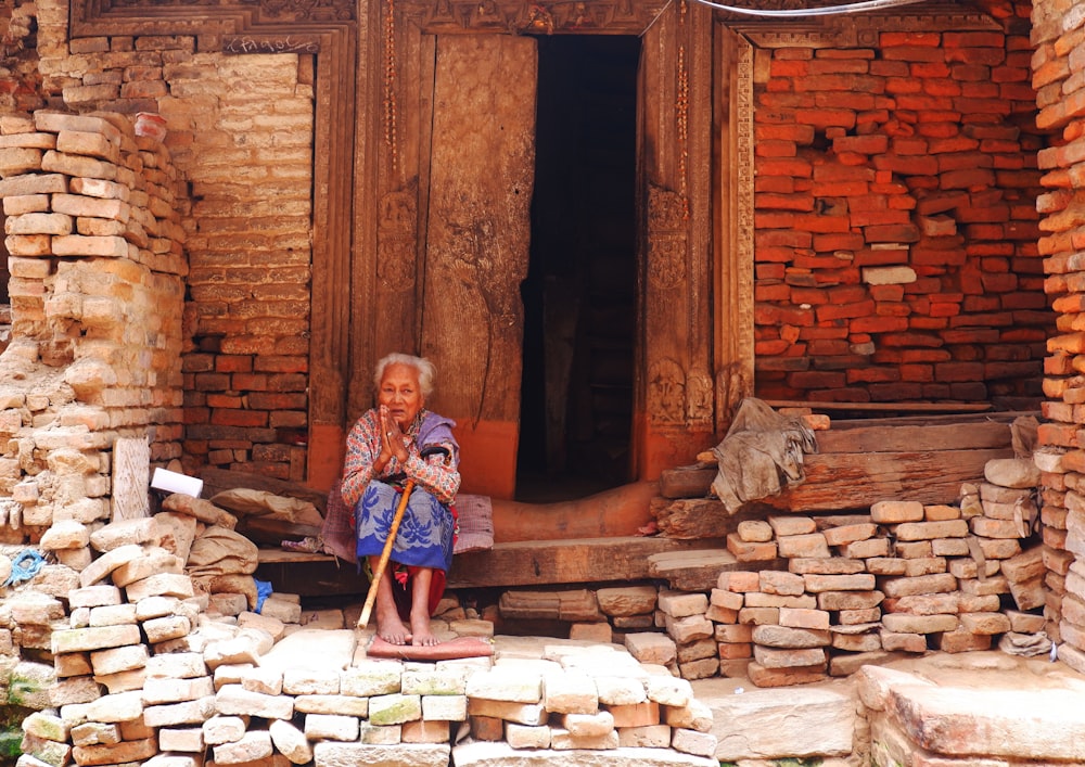 woman in blue and white dress standing on brown stone