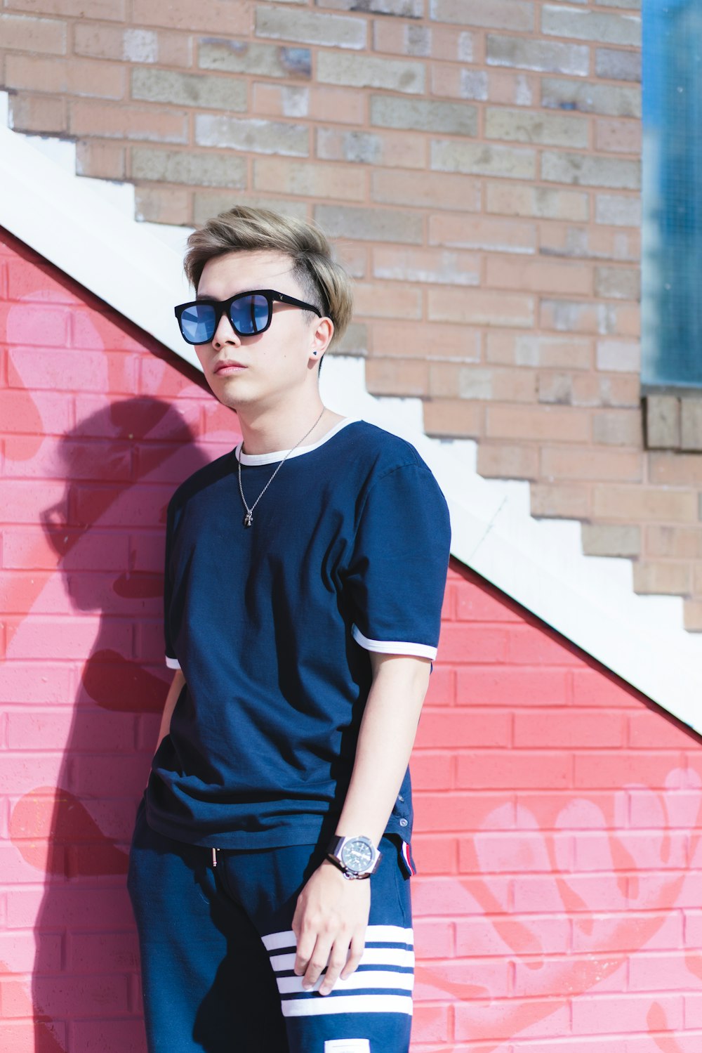 woman in blue v neck t-shirt and blue denim jeans wearing black sunglasses