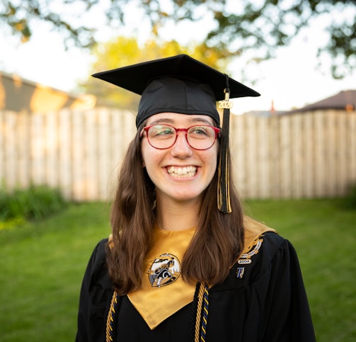 smiling woman in academic dress wearing academic hat