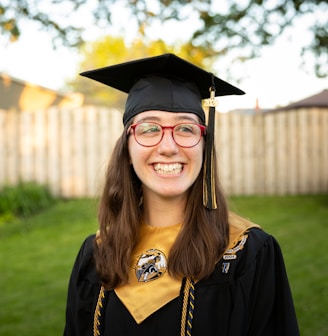 smiling woman in academic dress wearing academic hat