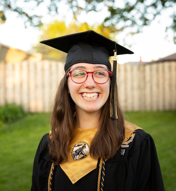 smiling woman in academic dress wearing academic hat