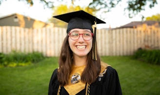 smiling woman in academic dress wearing academic hat