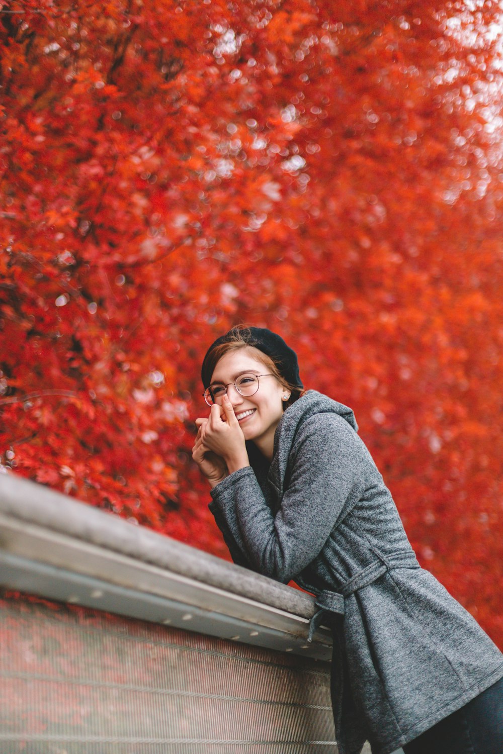 woman in gray sweater sitting on brown wooden bench