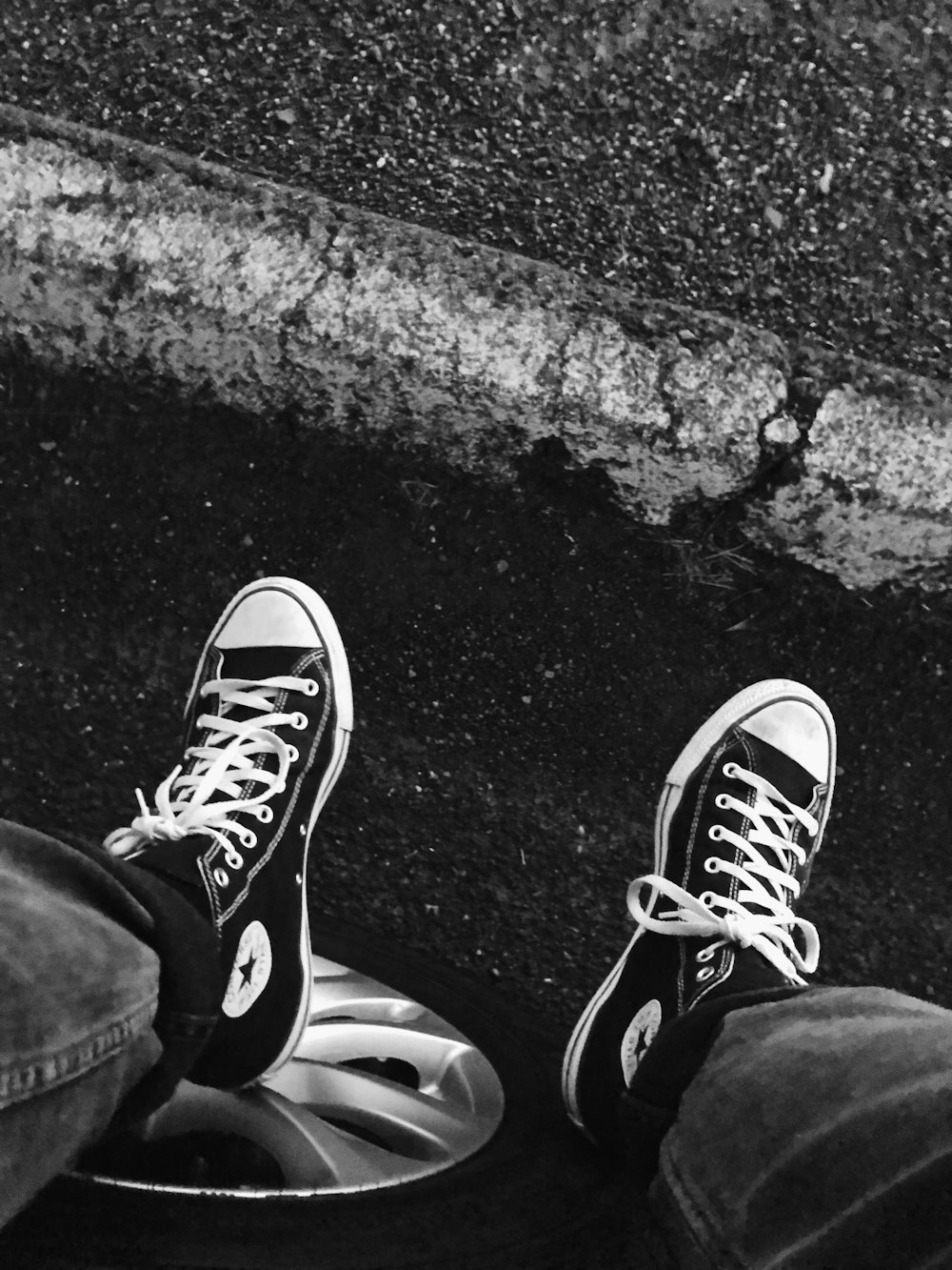 person wearing black and white converse all star high top sneakers