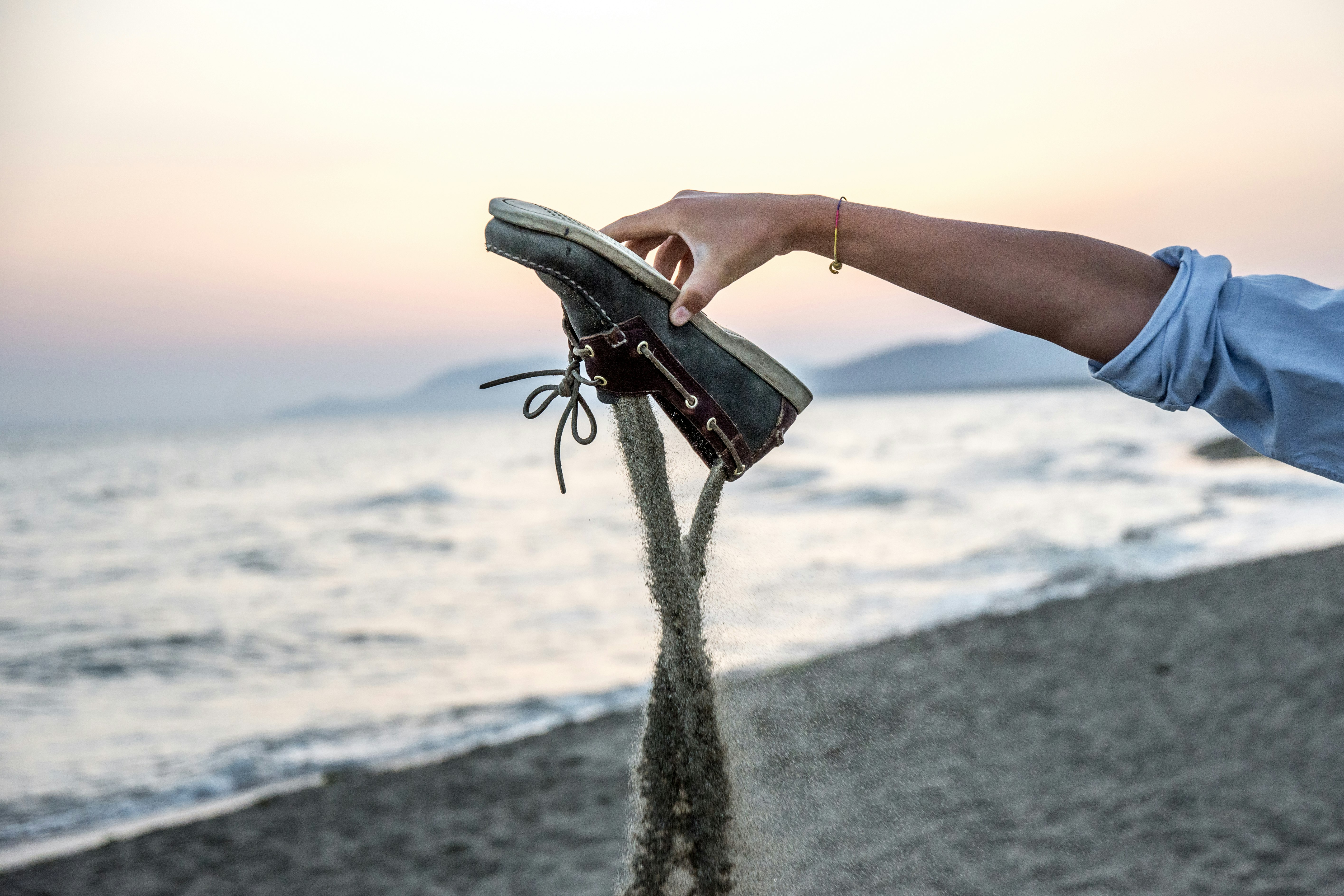 person holding black leather bag on beach during daytime