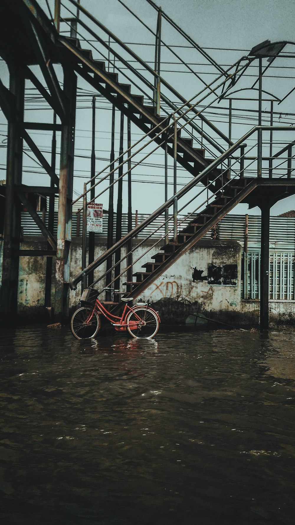 red bicycle on black metal ladder