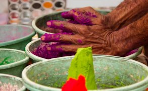 person holding green powder on green plastic basin
