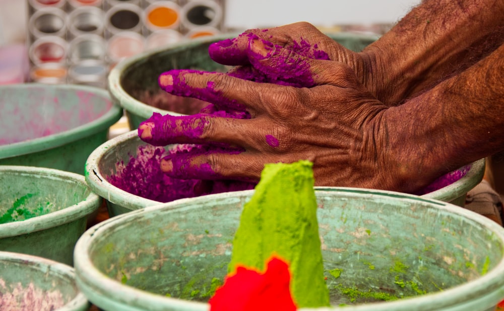 person holding green powder on green plastic basin