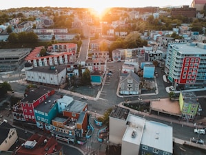 A vibrant aerial shot of a Houston neighborhood at sunset, showcasing a mix of modern homes and lush greenery.