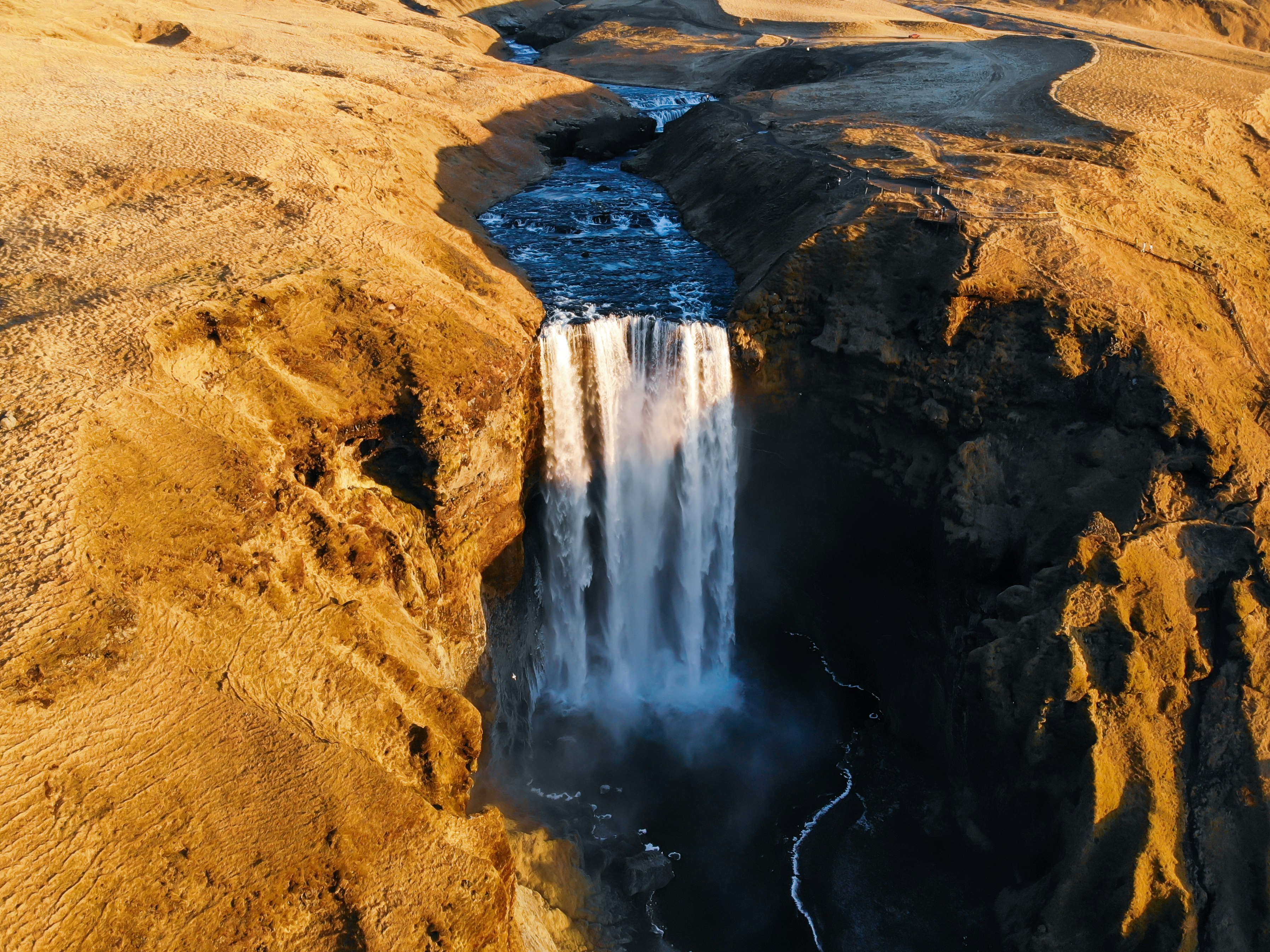 waterfalls on brown sand during daytime