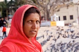 woman in red hijab standing on snow covered ground during daytime