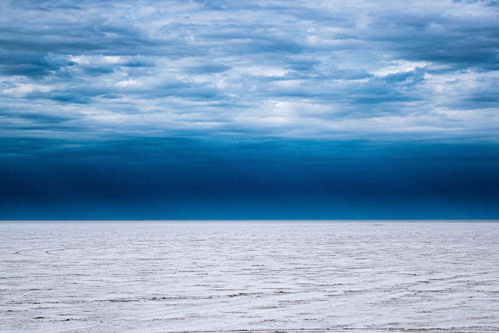 body of water under cloudy sky during daytime