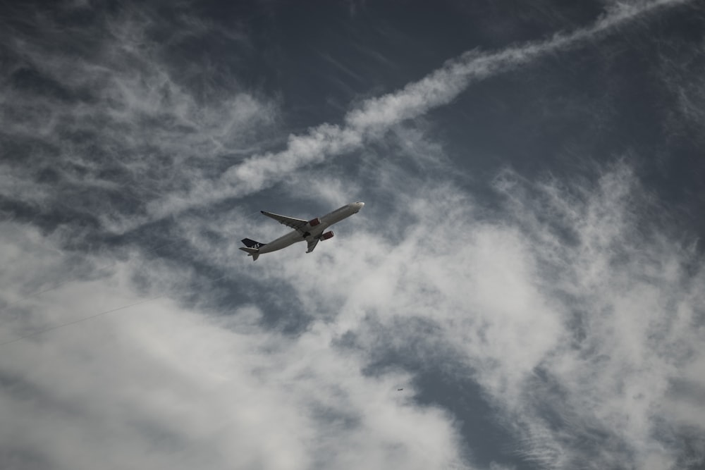 white airplane flying in the sky during daytime