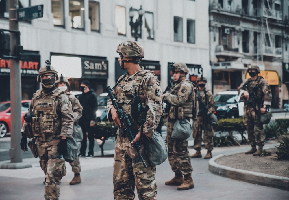 soldiers in black and brown camouflage uniform holding rifle