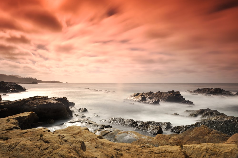 black rock formation on sea shore during daytime