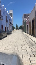 Colorful colonial street with vibrant buildings and cobblestone path.