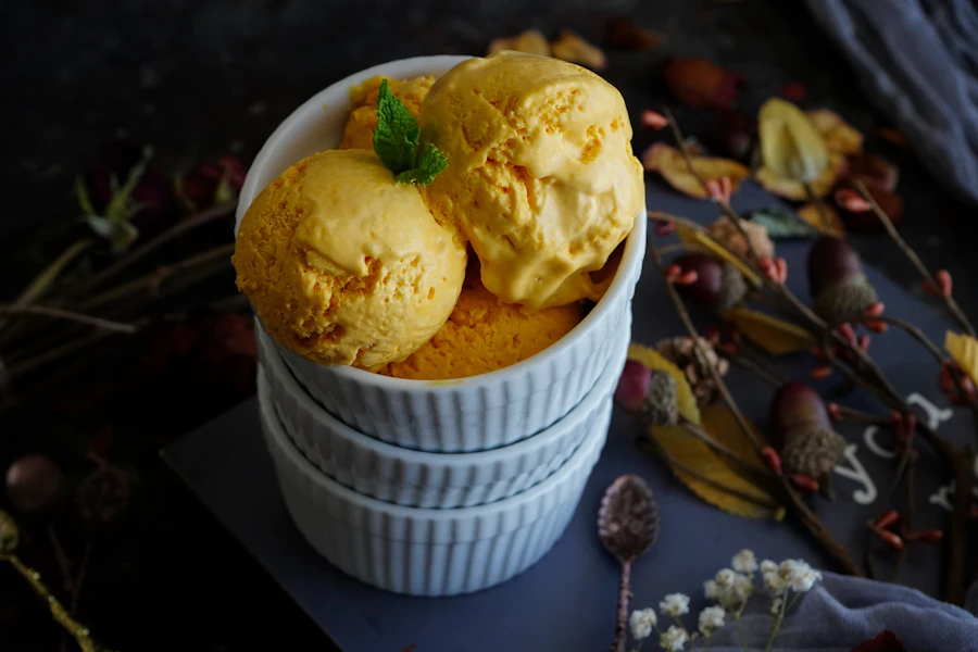 Mango ice cream scoops in a white bowl