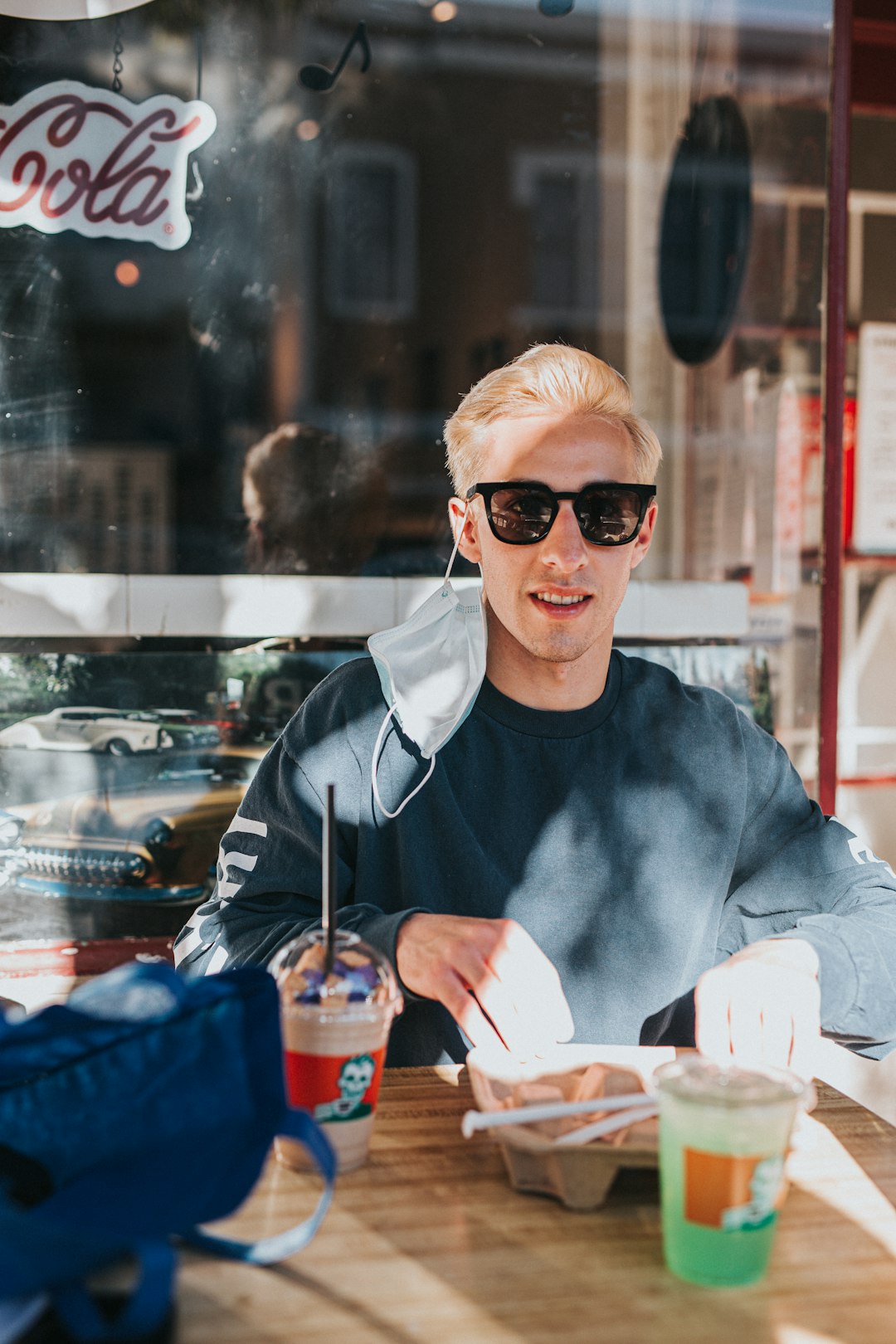 man in black crew neck long sleeve shirt wearing black sunglasses holding clear drinking glass