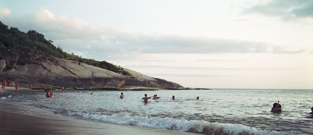 people swimming on sea during daytime