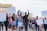 A diverse group of people is marching, holding various protest signs that call for justice and change. Many demonstrators have raised fists, indicating solidarity and determination. The participants are dressed casually and some wear masks. The setting appears to be an urban street.