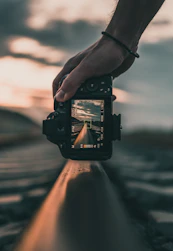 person holding black dslr camera during daytime