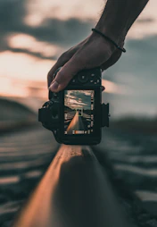 person holding black dslr camera during daytime
