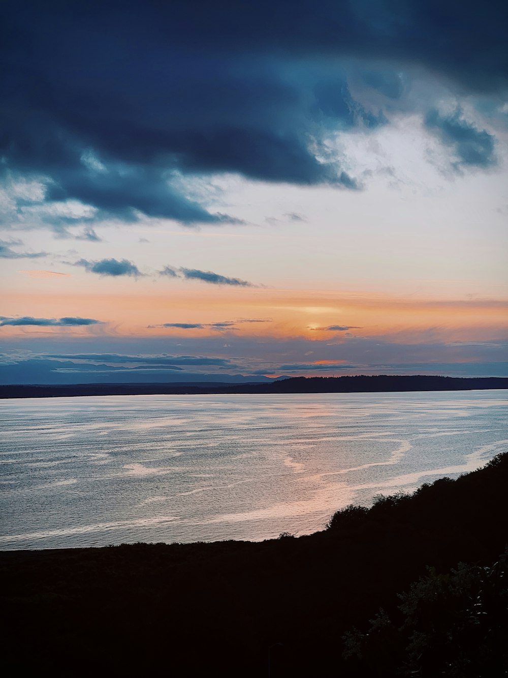 body of water under cloudy sky during sunset