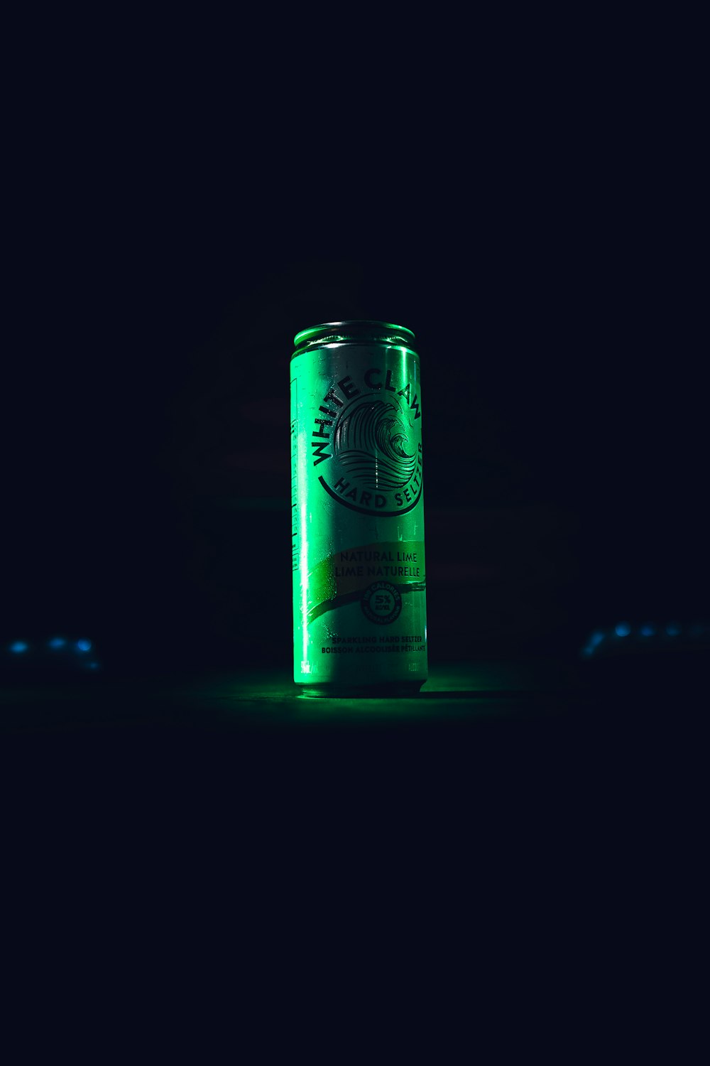 green and white can on black surface