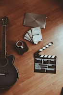 black and white electric guitar beside black and white ceramic mug on brown wooden table