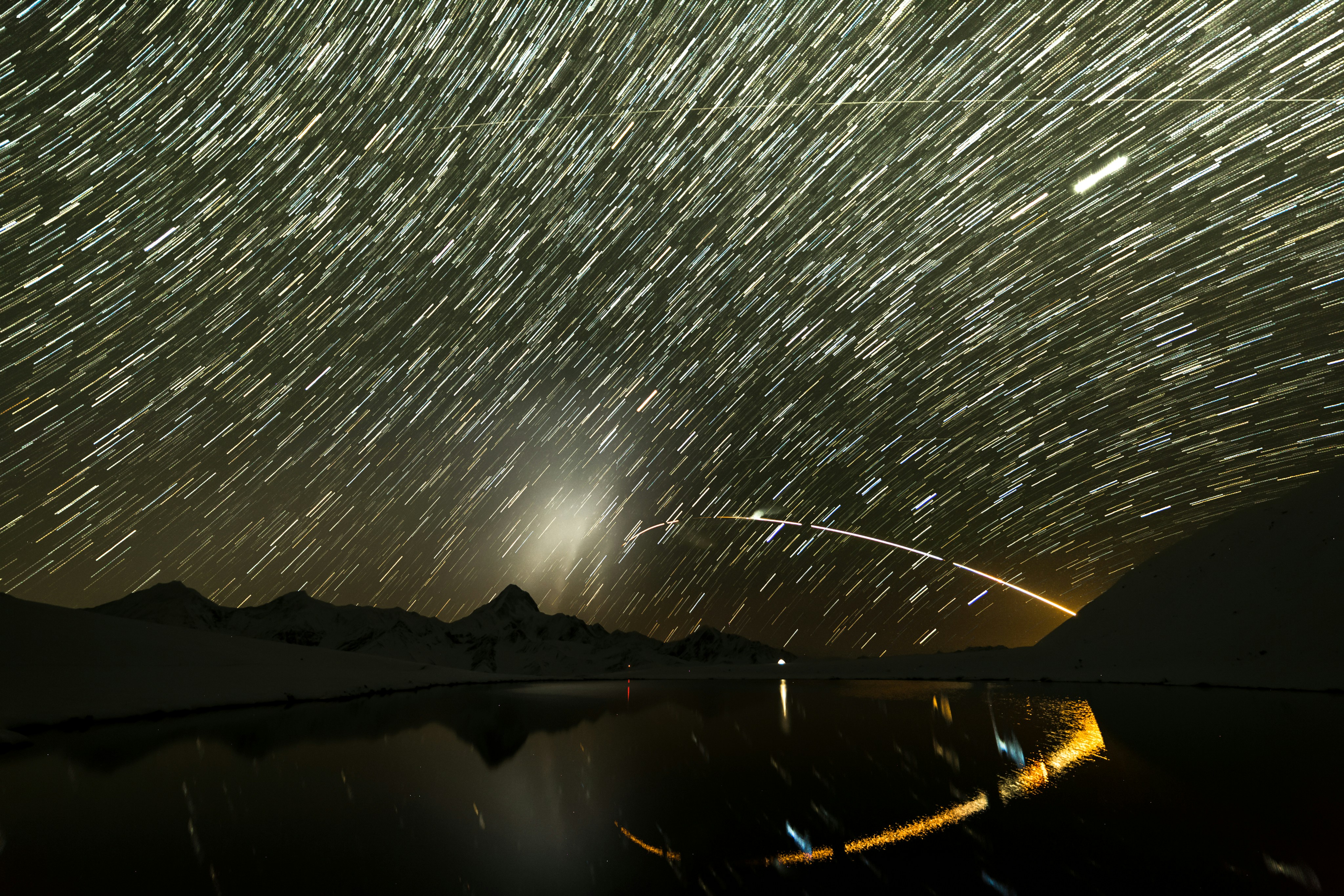 body of water near mountain during night time