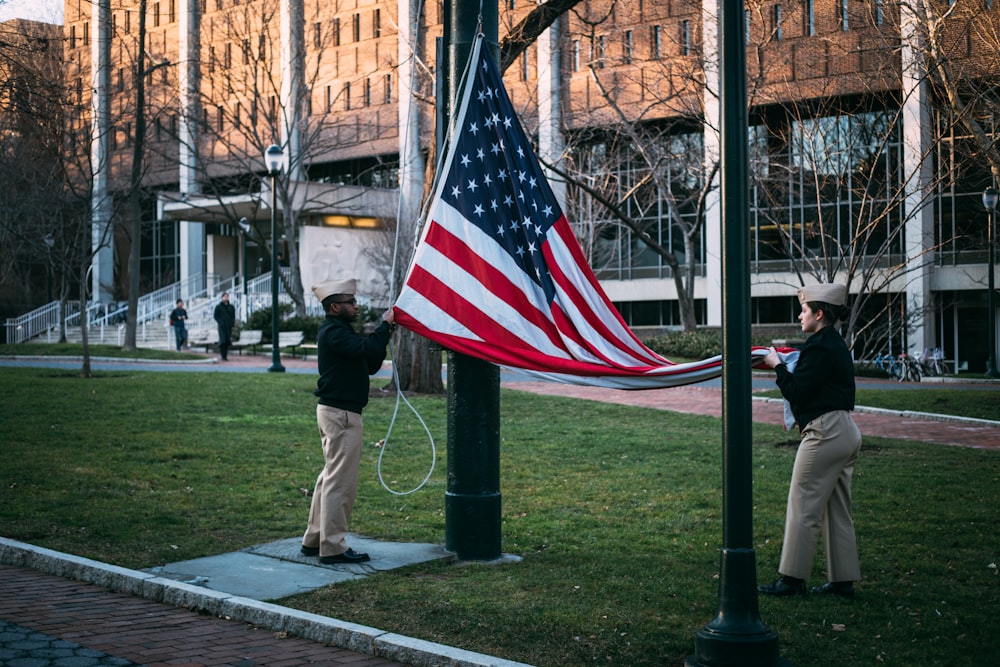 people walking on sidewalk with us a flag during daytime