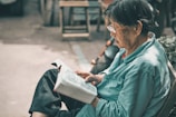 A volunteer handing a book to an elderly reader at a community literacy outreach