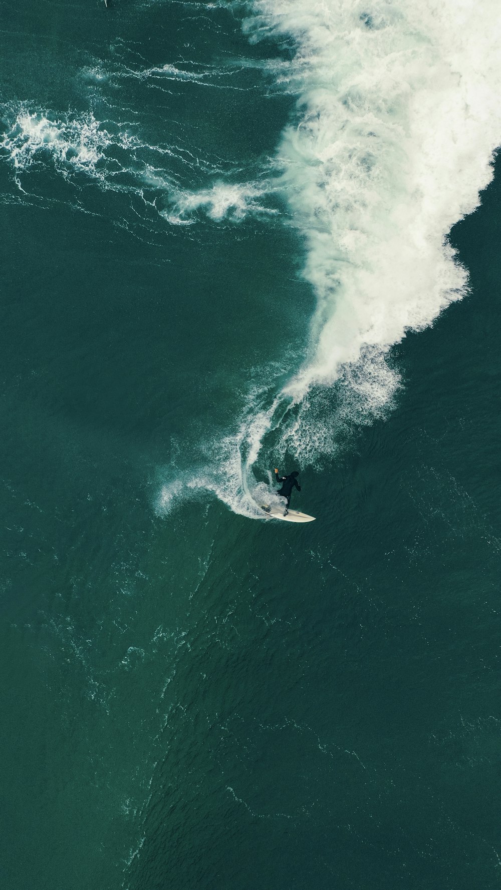 person surfing on sea waves during daytime