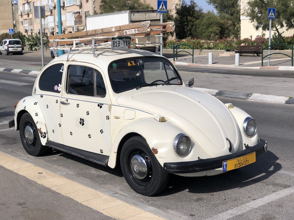 white volkswagen beetle parked on sidewalk during daytime