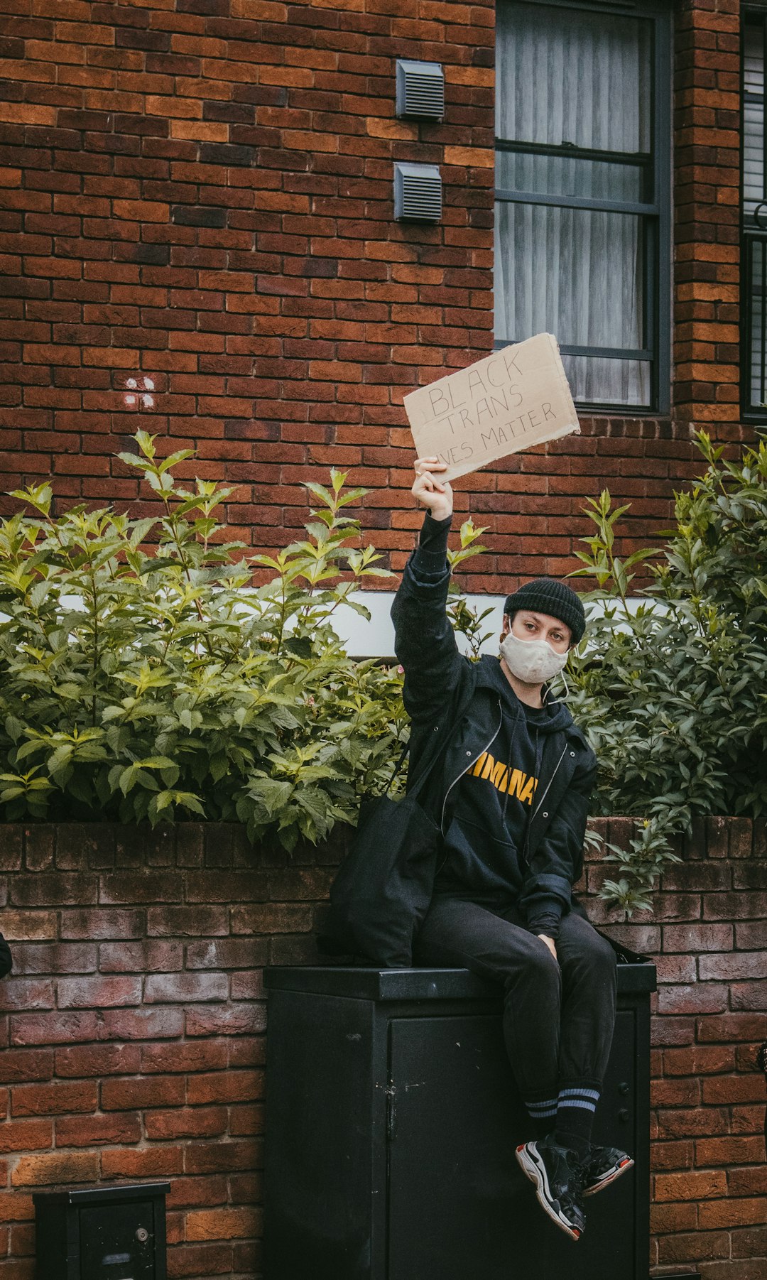 man in black jacket holding white card