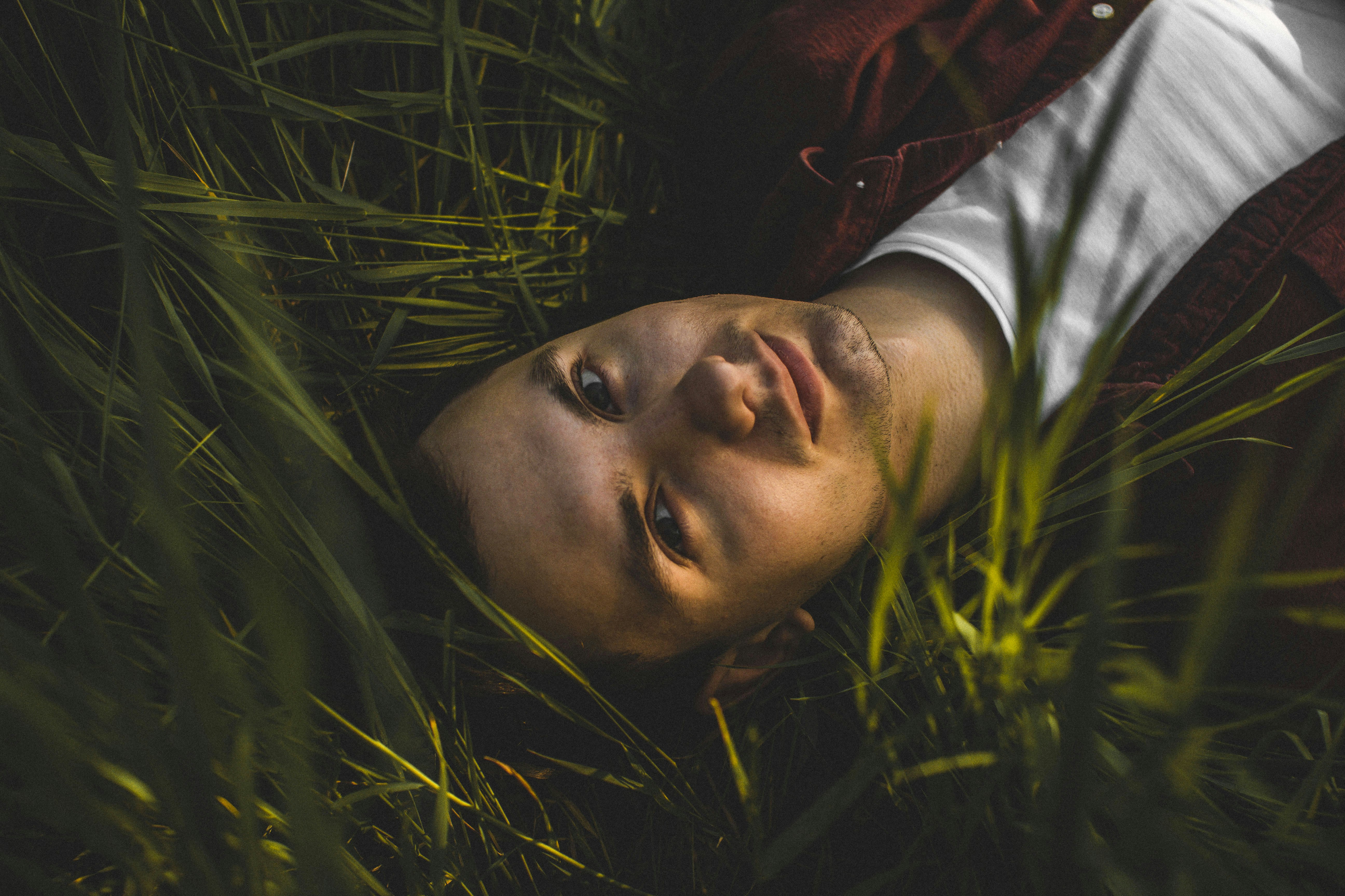 woman in red jacket lying on green grass