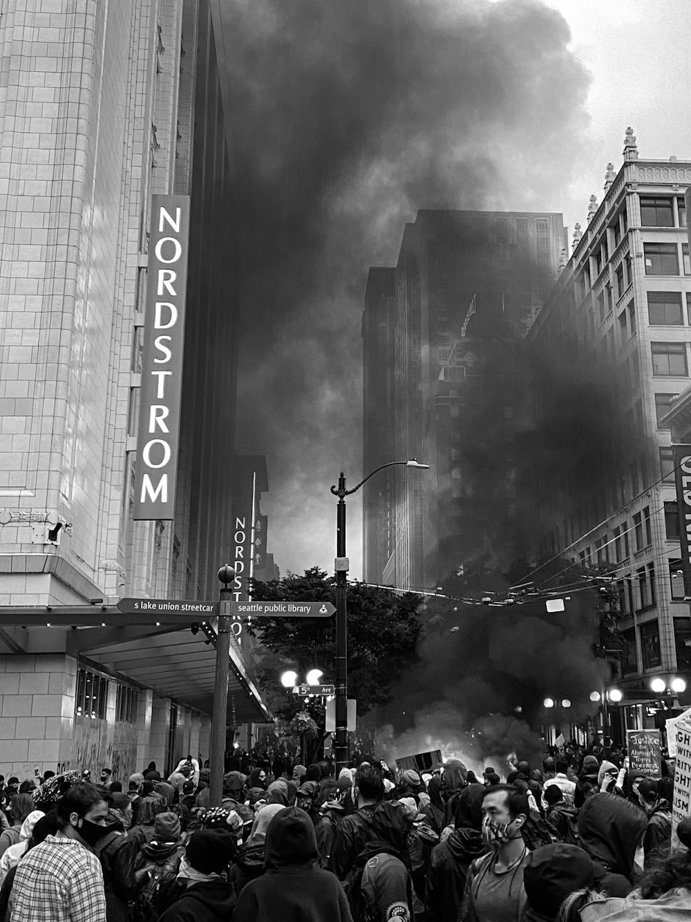 grayscale photo of people walking on street near building