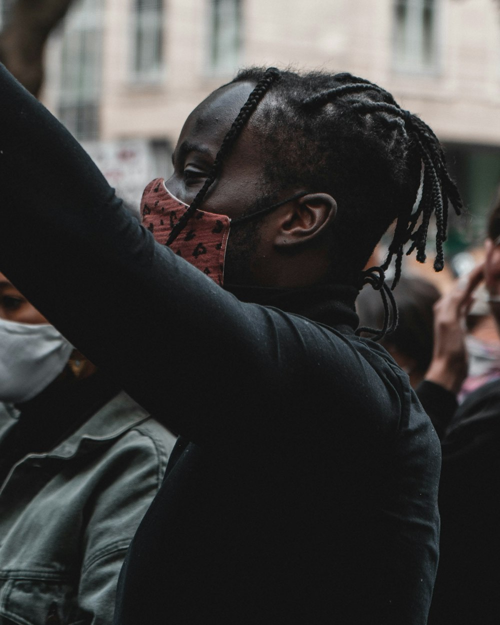 man in black jacket holding his head