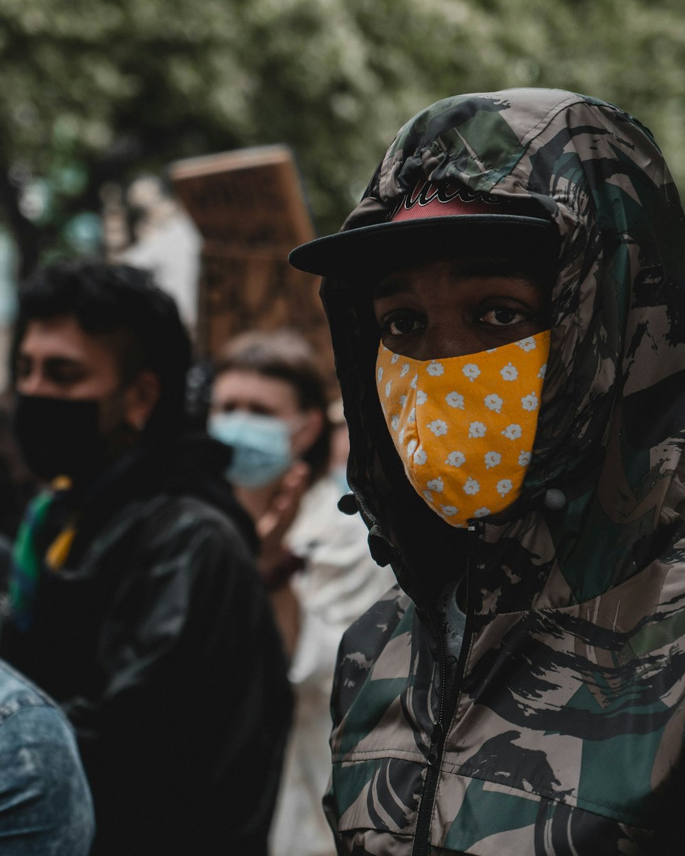 person wearing camouflage jacket and mask