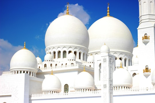 white and brown dome building under blue sky during daytime in Sheikh Zayed Grand Mosque Center United Arab Emirates
