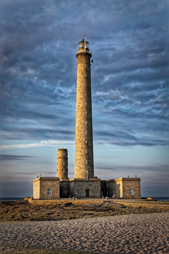 brown concrete tower under cloudy sky during daytime in Gatteville Lighthouse France