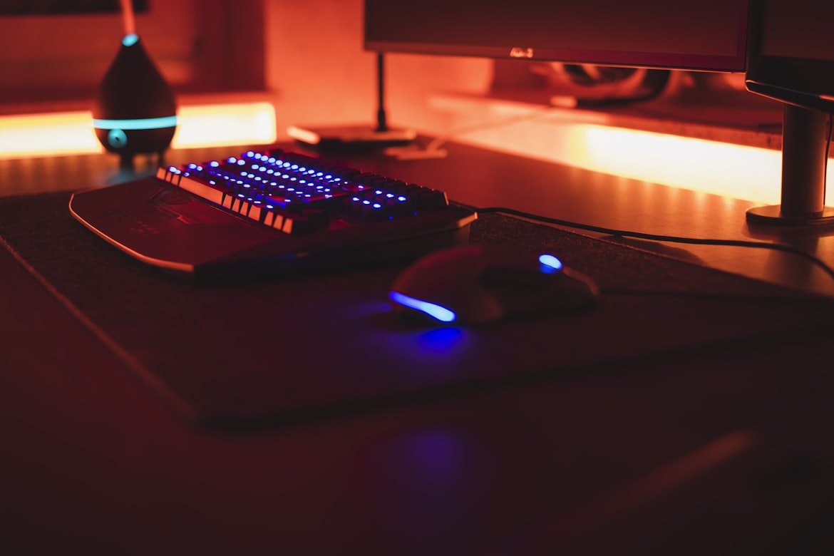 dark mouse and keyboard with blue light standing on a desktop with an overall red light