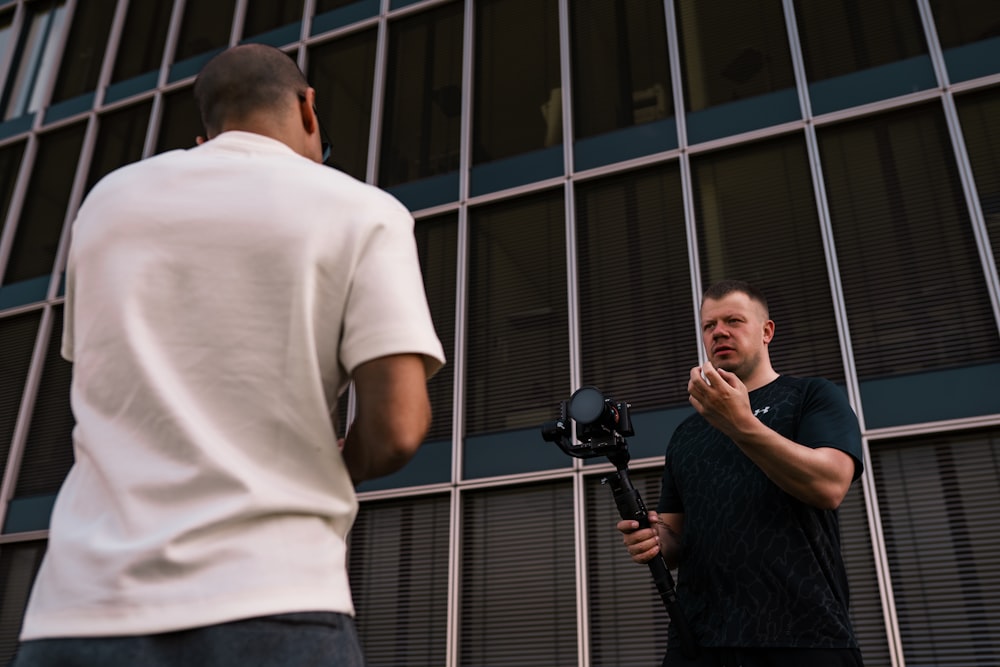 man in white t-shirt standing beside man in black t-shirt