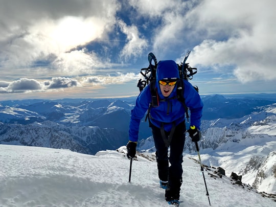 man in blue jacket and blue pants standing on snow covered ground during daytime in Posets Spain